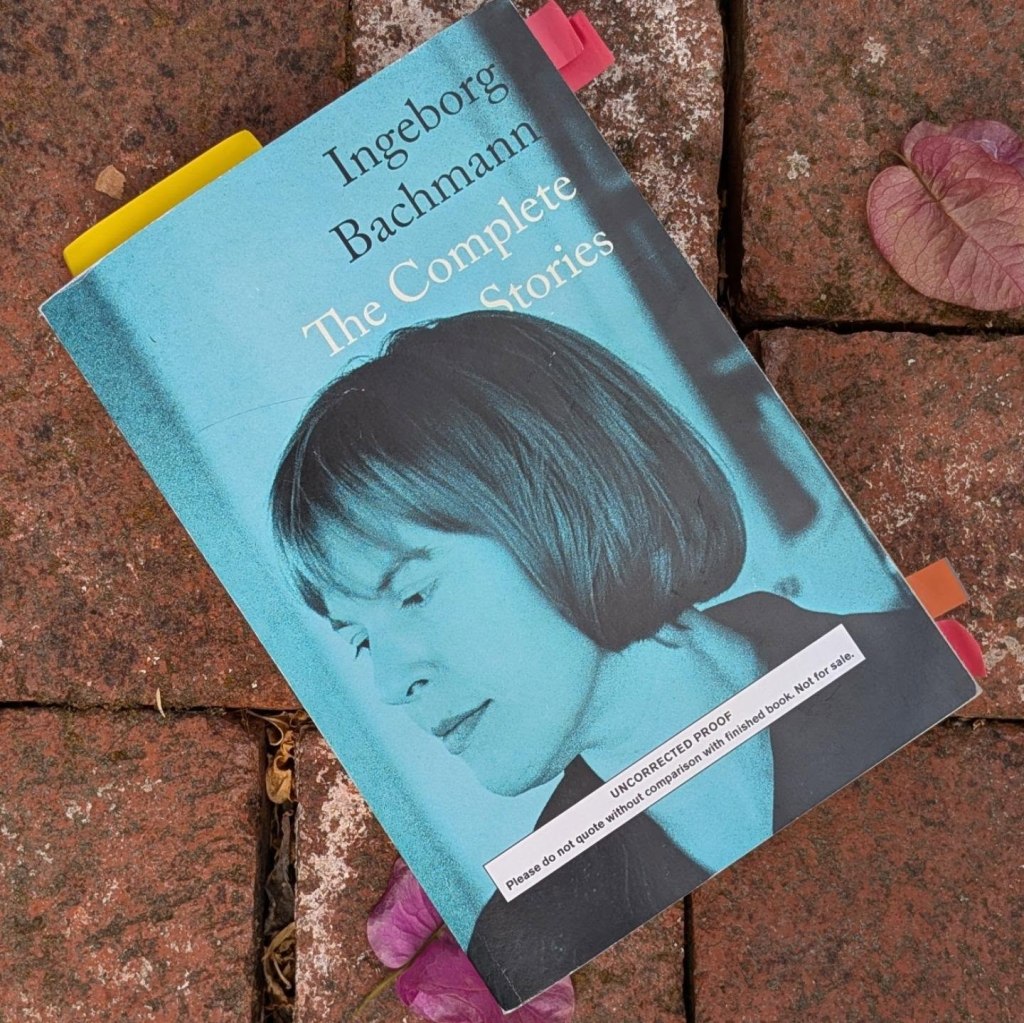 Book cover tinted blue with a woman's face on the cover, against brick background with bougainvillea flowers.